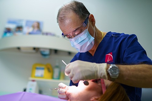 an image of a male dentist checking up on a patient for dental crowns at TLC Dental Darlinghurst