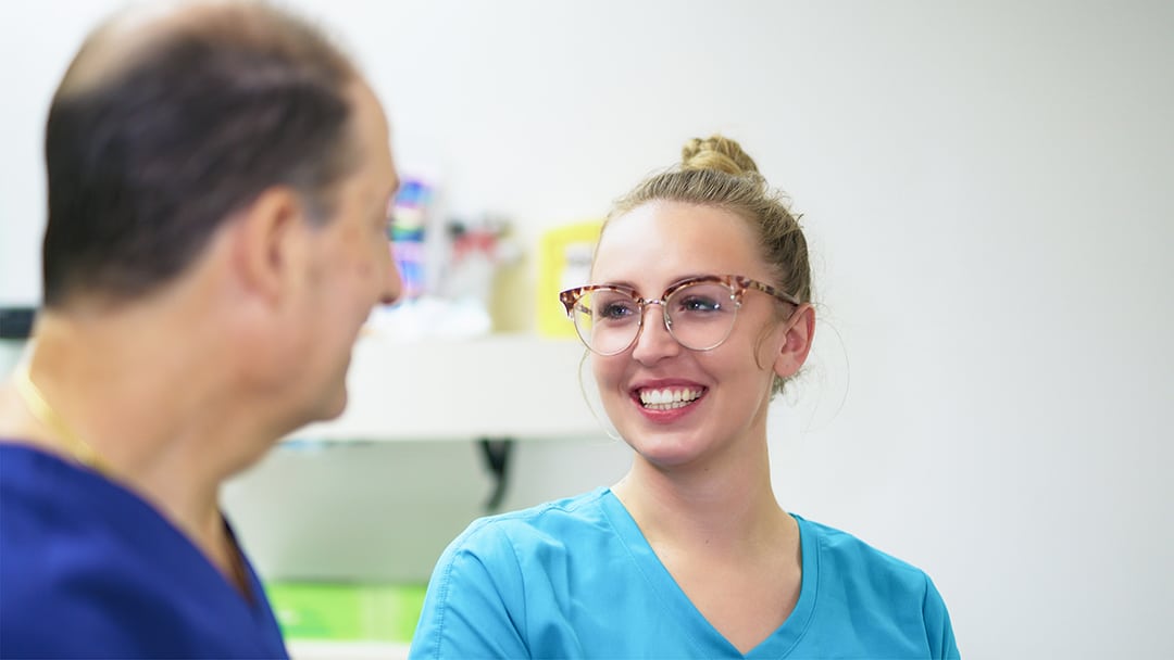 an image of a dentist talking to a patient about can invisalign fix an overbite at TLC Dental